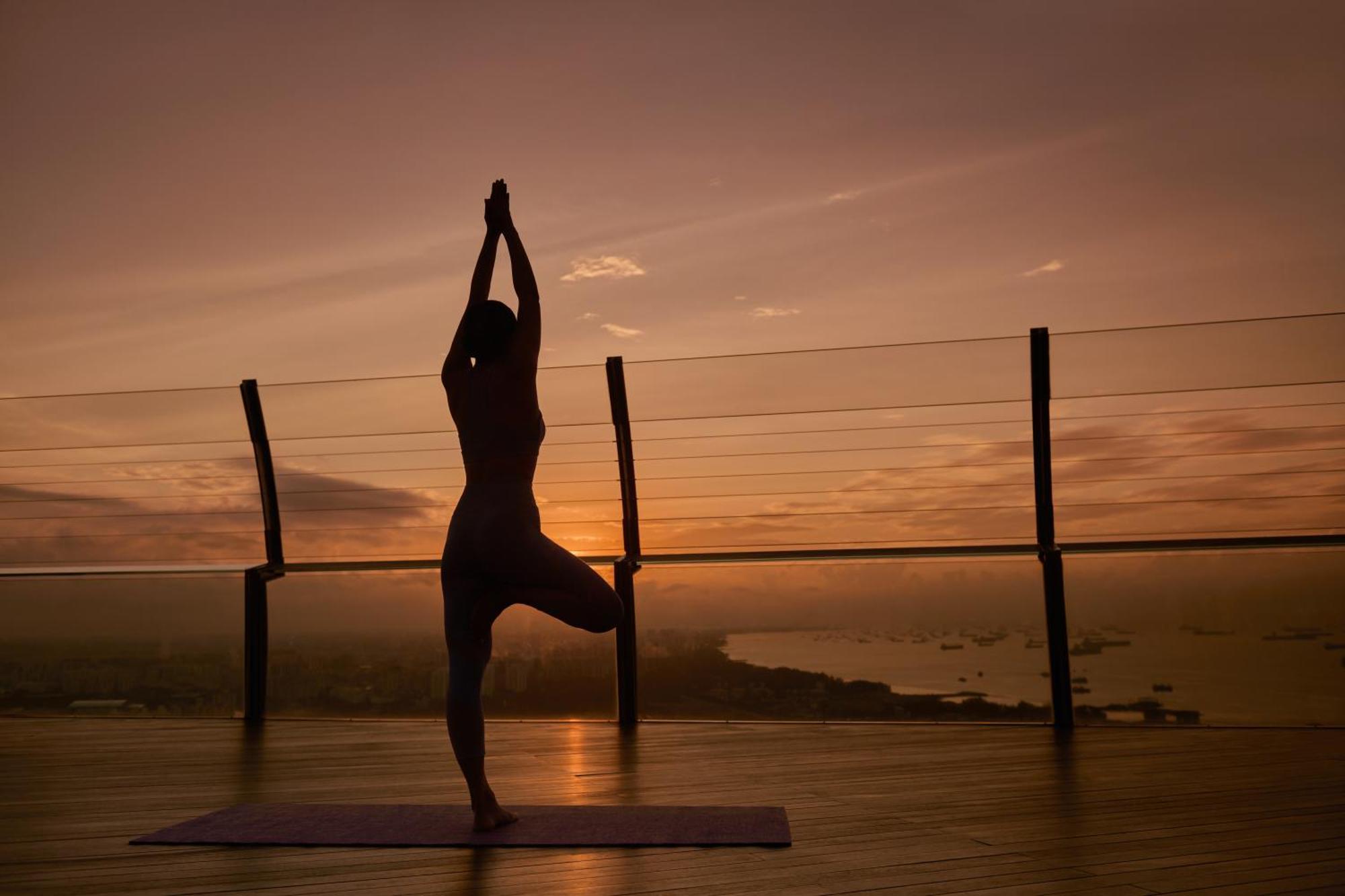 Marina Bay Sands Singapore Buitenkant foto A woman practicing yoga on a rooftop